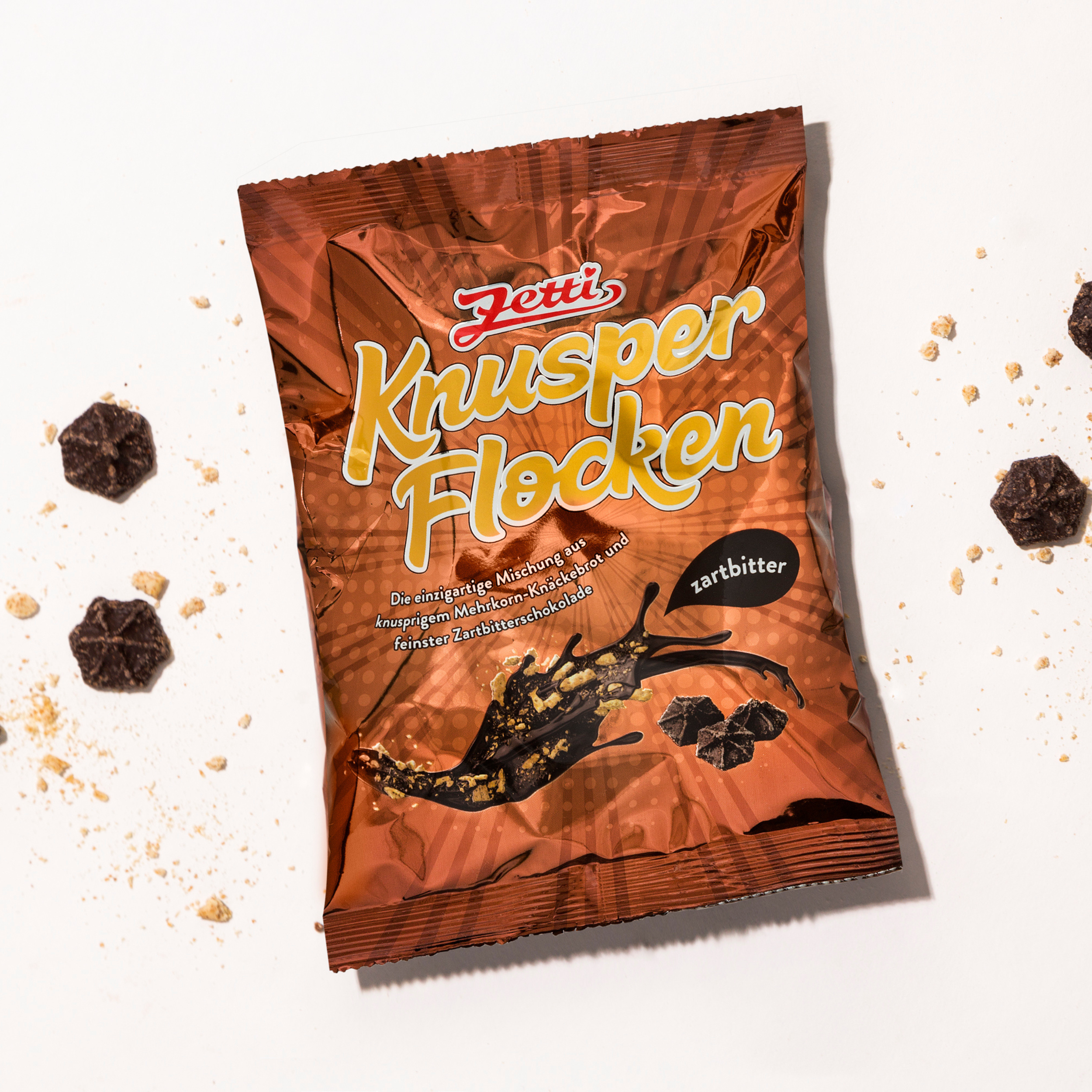 Zetti Knusperflocken Zartbitter Vorderseite einer Packung Zetti Knusperflocken Zartbitter eingebettet in Zetti Knusperflocken Zartbitter