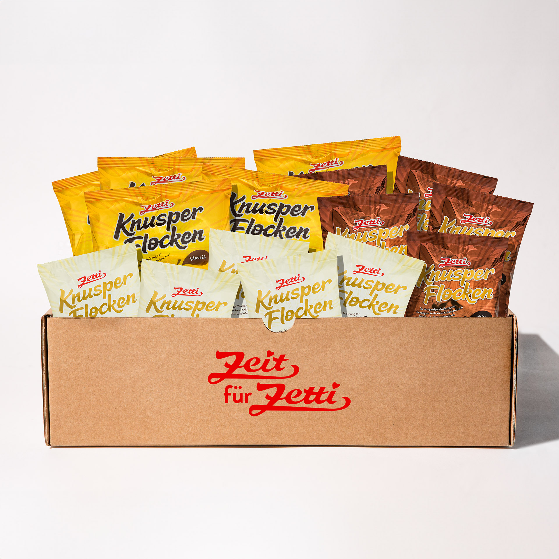 Zetti Knusperflocken Explosion Eine Abbildung von einem Karton, in dem sich verschiedene Tüten Zetti Knusperflocken befinden
